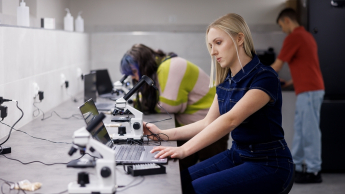 Logistyka produkcji | Studia I stopnia w Gdyni | Uniwersytet WSB Merito Gdynia: Studentka przy mikroskopie