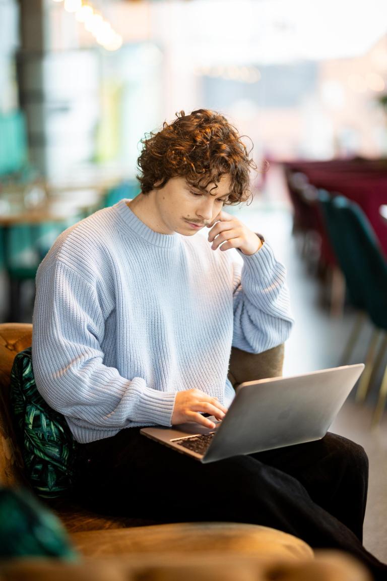 Zasady rekrutacji | Uniwersytet WSB Merito Gdynia: Chłopak zapisuje się na studia używając laptopa