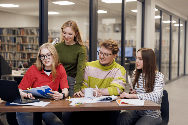 Informatyka | Studia I stopnia w Gdyni | Uniwersytet WSB Merito Gdynia: Studenci przy biurku pracują razem nad zagadnieniem