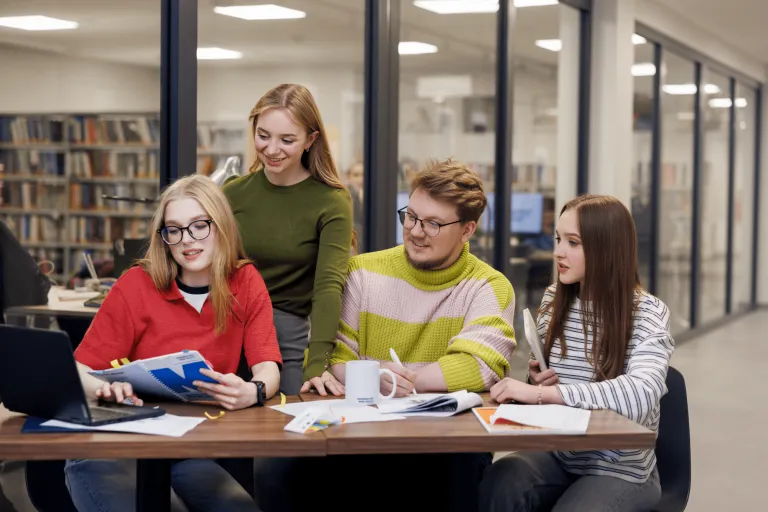Technologie sztucznej inteligencji | Studia I stopnia w Gdyni | Uniwersytet WSB Merito Gdynia: Studenci przy biurku pracują razem nad zagadnieniem