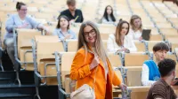 Zintegrowane systemy informatyczne – SAP ERP | Studia podyplomowe w Łodzi | Uniwersytet WSB Merito Łódź: Studentka uśmiecha się do obiektywu na sali wykładowej Uniwersytetu WSB Merito w Łodzi