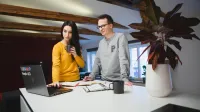 Sztuczna inteligencja w biurze | Uniwersytet WSB Merito Łódź: Kobieta i mężczyzna spoglądają na laptop w domu.
