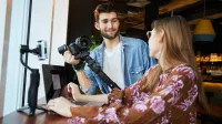 Media i komunikacja w biznesie | Uniwersytet WSB Merito Łódź: Dwoje młodych ludzi pracuje wspólnie nad projektem medialnym.
