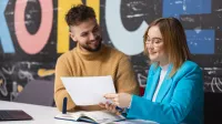Trener biznesu i rozwoju organizacji | Uniwersytet WSB Merito Łódź: Studenci pracują nad wspólną pracą na Uniwersytecie WSB Merito w Łodzi