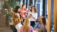 Well-being w organizacji – nowoczesne podejście do zdrowia, relacji i efektywności | Uniwersytet WSB Merito Łódź: Grupa ludzi rozmawia przy stole.