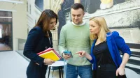 Digital marketing | Uniwersytet WSB Merito Łódź: Trzy osoby przeglądają telefon.