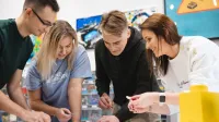 Pentester - specjalista ds.   cyberbezpieczeństwa | Studia podyplomowe w Łodzi | Uniwersytet WSB Merito Łódź: Studenci Uniwersytetu WSB Merito w Łodzi pracują wspólnie nad projektem.
