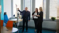 Bezpieczeństwo i higiena pracy | Uniwersytet WSB Merito Łódź: 3 osoby przy tablicy zebranie 