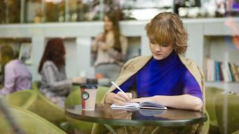 Bankowość, ubezpieczenia i rynki finansowe | Studia I stopnia w Łodzi | Uniwersytet WSB Merito Łódź: Studentka Uniwersytetu WSB Merito w Łodzi uczy się w parku.