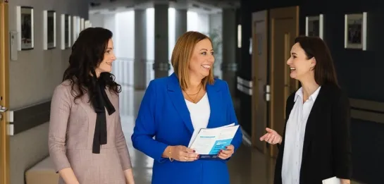 Studia MBA w Łodzi | Uniwersytet WSB Merito Łódź: uczestniczki MBA trzy rozmawiają na korytarzu na uczelni 