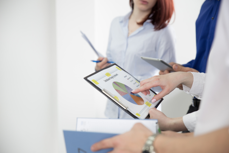 Fintech - innowacje technologiczne na   rynku finansowym | Studia podyplomowe w Opolu | Uniwersytet WSB Merito Opole: Grupa osób omawia wspólnie wykres kołowy