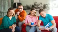 Media i komunikacja w biznesie | Studia I stopnia w Opolu | Uniwersytet WSB Merito Opole: Grupa młodych ludzi siedzi na kanapie i rozmawia