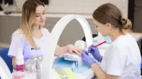 Kosmetologia | Studia I stopnia w Opolu | Uniwersytet WSB Merito Opole: Główna grafika: Opole - kosmetologia - studentki w pracowni kosmetologicznej, wykonują zabieg na paznokciach
