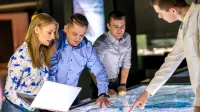 Administracja i bezpieczeństwo wewnętrzne | Studia II stopnia w Opolu | Uniwersytet WSB Merito Opole: Główna grafika: Opole - studia II stopnia - grupa studentów przyglądająca się mapie elektronicznej
