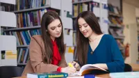 Wywiad i detektywistyka | Uniwersytet WSB Merito Opole: Główna grafika: Opole - specjalność Administracja bezpieczeństwa publicznego - studentki w bibliotece