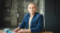 Bankowość cyfrowa | Studia podyplomowe w Opolu | Uniwersytet WSB Merito Opole: Główna grafika: Opole - studia podyplomowe - Mężczyzna siedzący za biurkiem  