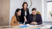 Negocjacje w biznesie | Studia podyplomowe w Opolu | Uniwersytet WSB Merito Opole: Główna grafika: Opole - studia podyplomowe - Negocjacje w biznesie - Grupa osób przeglądająca notatki