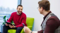 Służba cywilna w administracji | Studia I stopnia w Opolu | Uniwersytet WSB Merito Opole: Główna grafika: Opole - studia I stopnia - specjalność służba cywilna w administracji - Dwóch rozmawiających mężczyzn, jeden z nich korzysta z tabletu