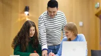 Doradztwo podatkowe | Uniwersytet WSB Merito Opole: Główna grafika: Opole - studia II stopnia - specjalność Doradztwo podatkowe - dwie studentki pracujące nad projektem pod okiem wykładowcy