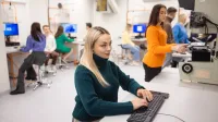 Inżynieria zarządzania | Studia I stopnia w Opolu | Uniwersytet WSB Merito Opole: Główna grafika: Opole - studia I stopnia - Inżynieria zarządzania - Grupa osób pracująca w laboratorium kierunkowym