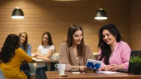 Digital marketing | Studia II stopnia w Opolu | Uniwersytet WSB Merito Opole: Główna grafika: Opole - studia II stopnia - specjalnosć Digital marketing - Dwie kobiety siedzące w kawiarni, przeglądają notatki