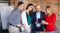 Neuroprzywództwo | Studia podyplomowe w Opolu | Uniwersytet WSB Merito Opole: Główna grafika: Opole - studia podyplomowe - Neuroprzywództwo - Grupa osób patrząca w ekran tabletu