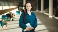 Zarządzanie finansami w przedsiębiorstwie | Studia podyplomowe w Opolu | Uniwersytet WSB Merito Opole: Główna grafika: Opole - studia podyplomowe -Zarządzanie finansami w przedsiębiorstwie- uczestniczka studiów podyplomowych stoi w korytarzu biblioteki z książką w ręce