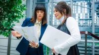 Studia menedżerskie | Studia podyplomowe w Opolu | Uniwersytet WSB Merito Opole: Główna grafika: Opole - studia podyplomowe - Studia menedżerskie - uczestniczki studiów podyplomowych analizują na korytarzu treści z kartek