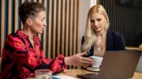 AI: prawo i etyka | Uniwersytet WSB Merito Opole: Główna grafika: Opole - studia podyplomowe - AI: prawo i etyka - uczestniczki studiów podyplomowych siedzą i rozmawiają, analizujać treści z laptopa
