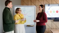 Główna grafika: Opole - studia podyplomowe - Copywriting sprzedażowy z AI - uczestnicy studiów podyplomowych rozmawiają wspólnie w sali na uczelni