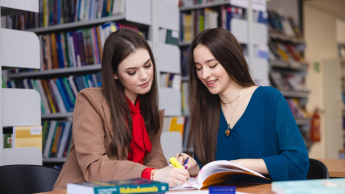 Wywiad i detektywistyka | Uniwersytet WSB Merito Opole: Główna grafika: Opole - specjalność Administracja bezpieczeństwa publicznego - studentki w bibliotece