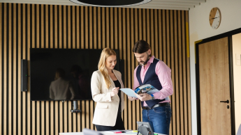 Event Manager | Studia podyplomowe w Opolu | Uniwersytet WSB Merito Opole: Główna grafika: Opole - studia podyplomowe - Dwie osoby przeglądające informator 