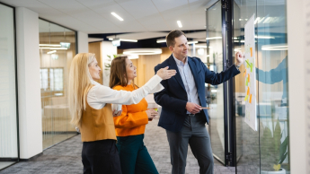 Social media i influencer marketing | Studia podyplomowe w Opolu | Uniwersytet WSB Merito Opole: Główna grafika: Opole - studia podyplomowe - Social media i influencer marketing - grupa osób przyglądająca się notatkom na samoprzylepnych karteczkach 