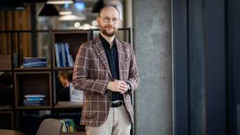 Zarządzanie jakością w branży automotive | Studia podyplomowe w Opolu | Uniwersytet WSB Merito Opole: Główna grafika: Opole - studia podyplomowe - Zarządzanie jakością w branży automotive - Mężczyzna stojący w kawiarni
