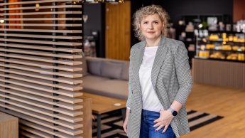 Agile – zwinne metodyki zarządzania projektami | Studia podyplomowe w Opolu | Uniwersytet WSB Merito Opole: Główna grafika: Opole - studia podyplomowe - Kobieta w marynarce stojąca w kawiarni