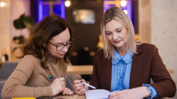 Bezpieczeństwo i higiena pracy | Studia podyplomowe w Opolu | Uniwersytet WSB Merito Opole: Główna grafika: Opole - studia podyplomowe - Bezpieczeństwo i higiena pracy - Dwie kobiety czytające notatki