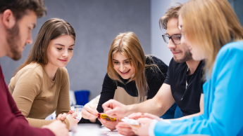 Inżynieria zarządzania | Studia I stopnia w Opolu | Uniwersytet WSB Merito Opole: Główna grafika: Opole - studia I stopnia - Inżynieria zarządzania -  Grupa osób grająca w grę karcianą