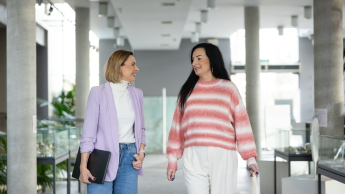 Kompetencje przyszłości - przewaga w świecie zmian | Studia podyplomowe w Opolu | Uniwersytet WSB Merito Opole: Główna grafika: Opole- studia podyplomowe- Kompetencje Przyszłości - Przewaga w Świecie Zmian- uczestniczki studiów podyplomowych rozmawiają, idąc koryatrzem