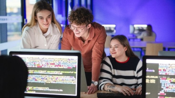 Informatyka | Studia I stopnia w Opolu | Uniwersytet WSB Merito Opole: Główna grafika: studia I stopnia inżynierskie - Informatyka - studenci analizują wspólnie treści na komputerze w sali komputerowej
