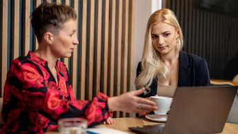 AI: prawo i etyka | Uniwersytet WSB Merito Opole: Główna grafika: Opole - studia podyplomowe - AI: prawo i etyka - uczestniczki studiów podyplomowych siedzą i rozmawiają, analizujać treści z laptopa
