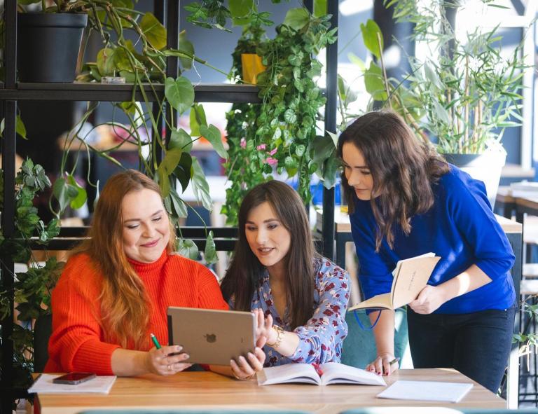 Centrum Współpracy z Biznesem | Uniwersytet WSB Merito Opole: Studentki Uniwersytetu WSB Merito Opole korzystające z laptopa i przeglądające notatki.