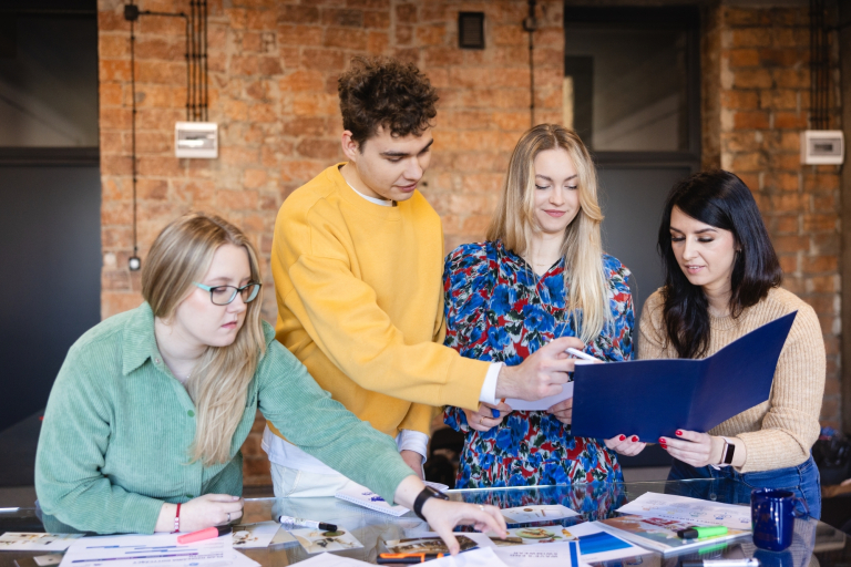 Organizacje i koła naukowe | Uniwersytet WSB Merito Opole: Główna grafika - Opole - stypendia i zniżki - grupa studentów przeglądająca notatki