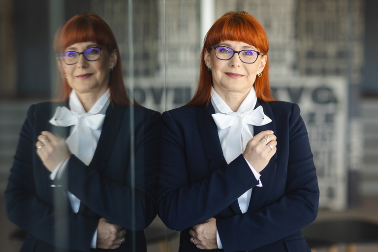 Studia MBA w Opolu | Uniwersytet WSB Merito Opole: Główna grafika: Opole - studia podyplomowe - Psychologia edukacyjna - Kobieta opierająca się o lustro, jest ubrana w granatową marynarkę