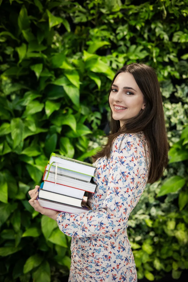 Psychologia | Studia jednolite magisterskie w Opolu | Uniwersytet WSB Merito Opole: Dziewczyna trzymająca w dłoniach stos książek
