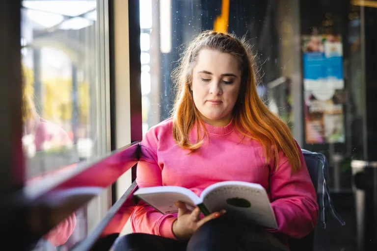 Informatyka | Studia I stopnia w Opolu | Uniwersytet WSB Merito Opole: Studentka siedzi i czyta książkę
