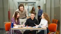 Ekologiczne aspekty zarządzania przedsiębiorstwem | Studia II stopnia ze studiami podyplomowymi  | Uniwersytet WSB Merito w Poznaniu: Grupa studentów pracuje przy stole