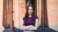 Filologia hiszpańska | Studia I stopnia w Poznaniu | Uniwersytet WSB Merito w Poznaniu: Studentka pozująca do zdjęcia przed nowoczesnym budynkiem uczelni.