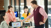 Administracja gospodarcza | Studia I stopnia w Poznaniu | Uniwersytet WSB Merito w Poznaniu: grupa rozmawia wskazując na ekran monitora