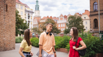 Angielska (English for Project Management) | Studia II stopnia ze studiami podyplomowymi  | Uniwersytet WSB Merito w Poznaniu: 2 dziewczyny i chłopak rozmawiają w centrum miasta Poznania