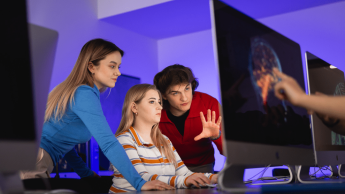 Big Data. Inżynieria danych | Studia podyplomowe w Poznaniu | Uniwersytet WSB Merito w Poznaniu: grupa studentów omawia projekt przed monitorem